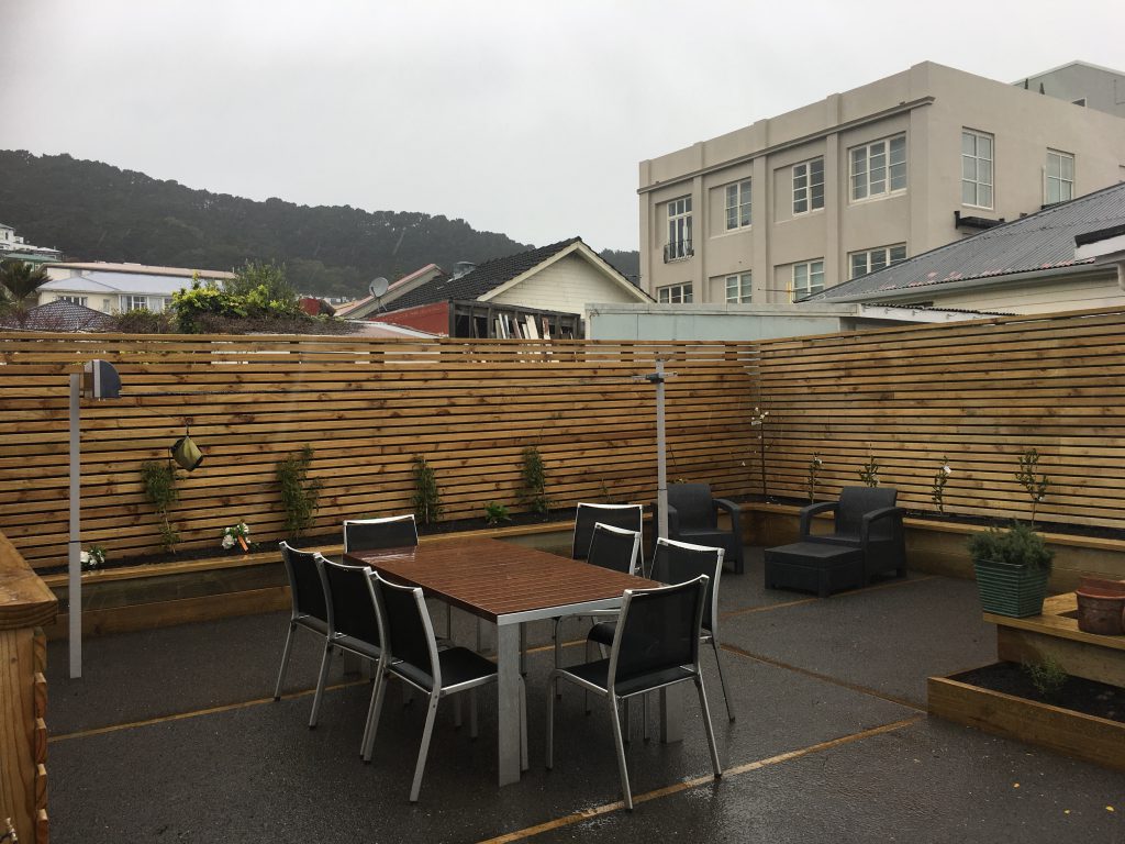Paved courtyard with an outdoor dining setting and a Wellington hillside view